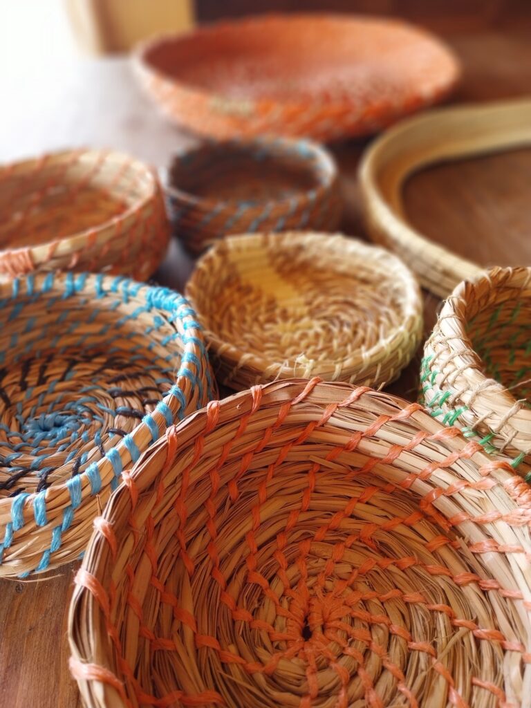 Conjunto de cestos artesanais criados com a técnica de coiling, utilizando fibras naturais e cordões coloridos. As diferentes texturas e padrões destacam a diversidade de peças produzidas durante um workshop de cestaria.