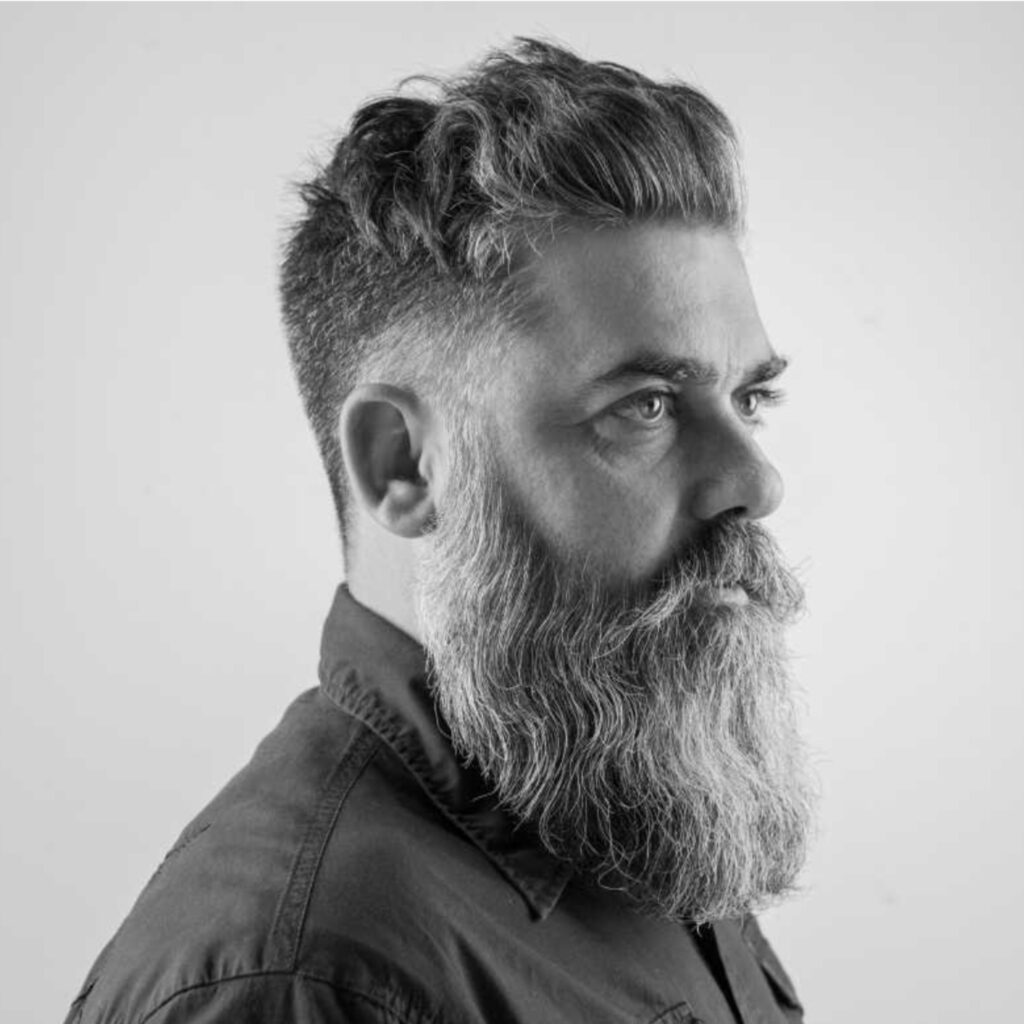 Fotografia em preto e branco de Vítor Agostinho, artista e designer, com expressão séria e olhar profundo.
